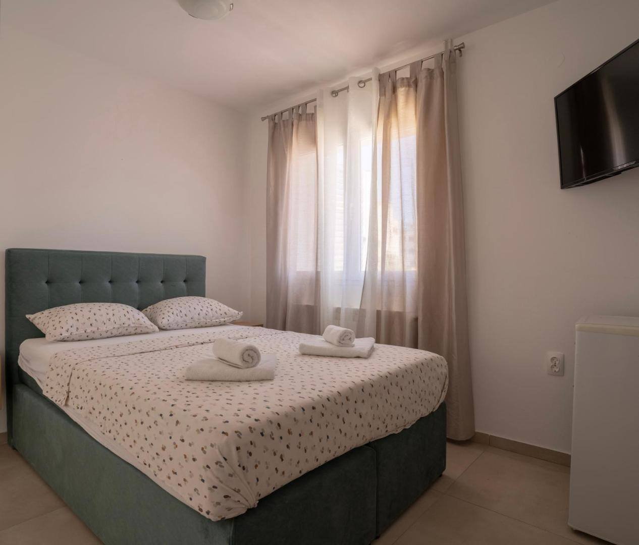 Apartments & Rooms Petra: double room with a green headboard and a TV