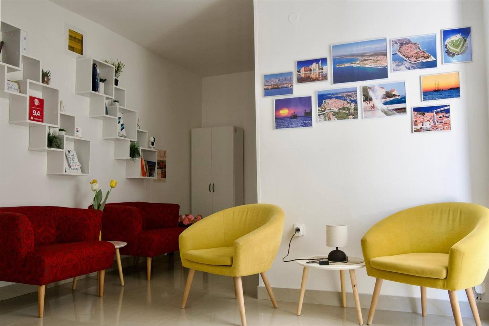 Apartments & Rooms Petra: lounge area with armchairs and photos of Zadar on the wall